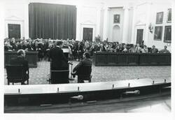 ["Black and white photograph print of Carl Albert speaking to a large group of people at an unidentified function."]