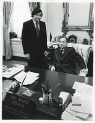 ["Black and white photograph print of Thurgood Marshall Jr. standing next to Carl Albert at Albert's desk."]