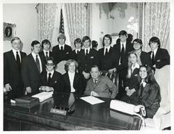 ["Black and white photograph print of Carl Albert posing with several unidentified people."]