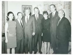 ["Black and white photograph print of Carl Albert standing with Hale Boggs and several other people. The inscription of the photograph reads: To my friend Carl Albert. From Hale Boggs."]