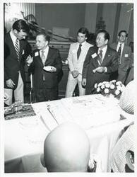 ["Black and white photograph print of Carl Albert and others eating the birthday cake."]