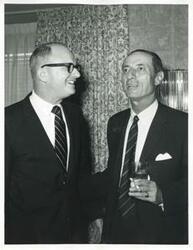 ["Black and white photograph print of Carl Albert speaking with unidentified women."]