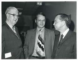 ["Black and white photograph print of Carl Albert and Tom Steed speaking with an unidentified man."]