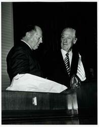 ["Black and white photograph print of Leslie Arends standing next to an unidentified man."]