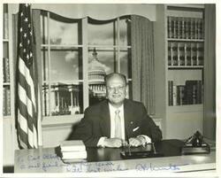 ["Black and white photograph print of Abe Multer seated at his desk."]