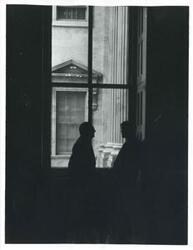 ["Black and white photograph print of Wilbur D. Mills speaking with an unidentified man."]