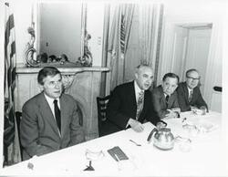 ["Black and white photograph print of Robert Strauss, Carl Albert, Russell B. Long, and another man at a Democratic leadership conference."]