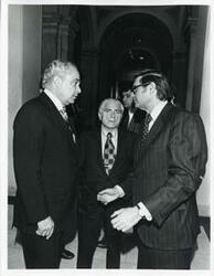 ["Black and white photograph print of Robert Strauss speaking with two unidentified men at a Democratic leadership conference."]