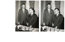 ["Two Black and White photograph prints of Carl Albert and another unidentified man standing behind Carl's office desk"]