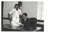 ["Black and white photograph of Carl Albert with a Naval officer looking over a report."]