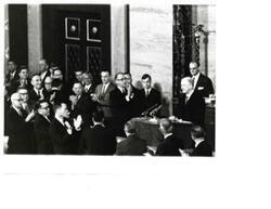 ["Black and white photograph of John W. McCormack speaking while Carl Albert, Mike Mansfield, and others applaud."]
