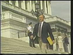 ["In the 1988 campaign ad for George Joseph Hochbrueckner, scenes depict him as a paragon of strength and dedication. Showcased lifting weights in a gym and demonstrating exercises, Hochbrueckner emphasizes hard work, both physically and in leadership, evidenced by a factory setting and his policy-driven speech at a podium. The slogan \"Hard Work, Real Results\" reinforces this theme."]