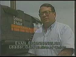["In the 1990 political TV ad, Republican candidate Jerry Solomon emphasizes his commitment to American jobs and local industries. Featuring scenes of him speaking at various events, Solomon advocates for the preservation of Delaware and Hudson Railroad jobs. He is shown receiving strong support from local communities and workers, consistently highlighting his dedication to employment preservation and industry stability within his region. The ad portrays Solomon as a staunch defender of American employment backed by an appreciative audience."]