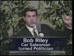 ["In the 1996 political TV ad, Democratic candidate Ted Little criticizes his opponent, Bob Riley. The ad portrays Riley as anti-education and pro-corporate welfare, highlighting various scenes of him speaking at podiums, often surrounded by supporters or protesters. The scenes emphasize Riley's controversial education budget cuts and apparent prioritization of corporate interests, visually amplifying the message with critical headlines and contrasting backdrops that accuse him of misleading political stances."]