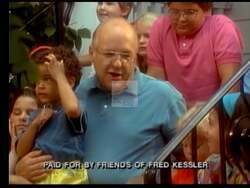 ["In the 1992 campaign ad, Democratic presidential candidate Fred Kessler passionately advocates for progressive reforms including industrial policy, women's rights, and national health insurance. Speaking confidently from various podiums, surrounded by American flags and campaign banners, Kessler addresses supportive and diverse audiences, focusing on civil rights and judicial reform."]